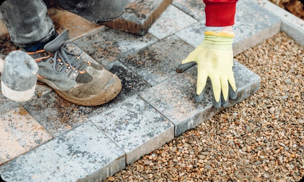 a specialist laying slabs and pavement on gravel for new driveway